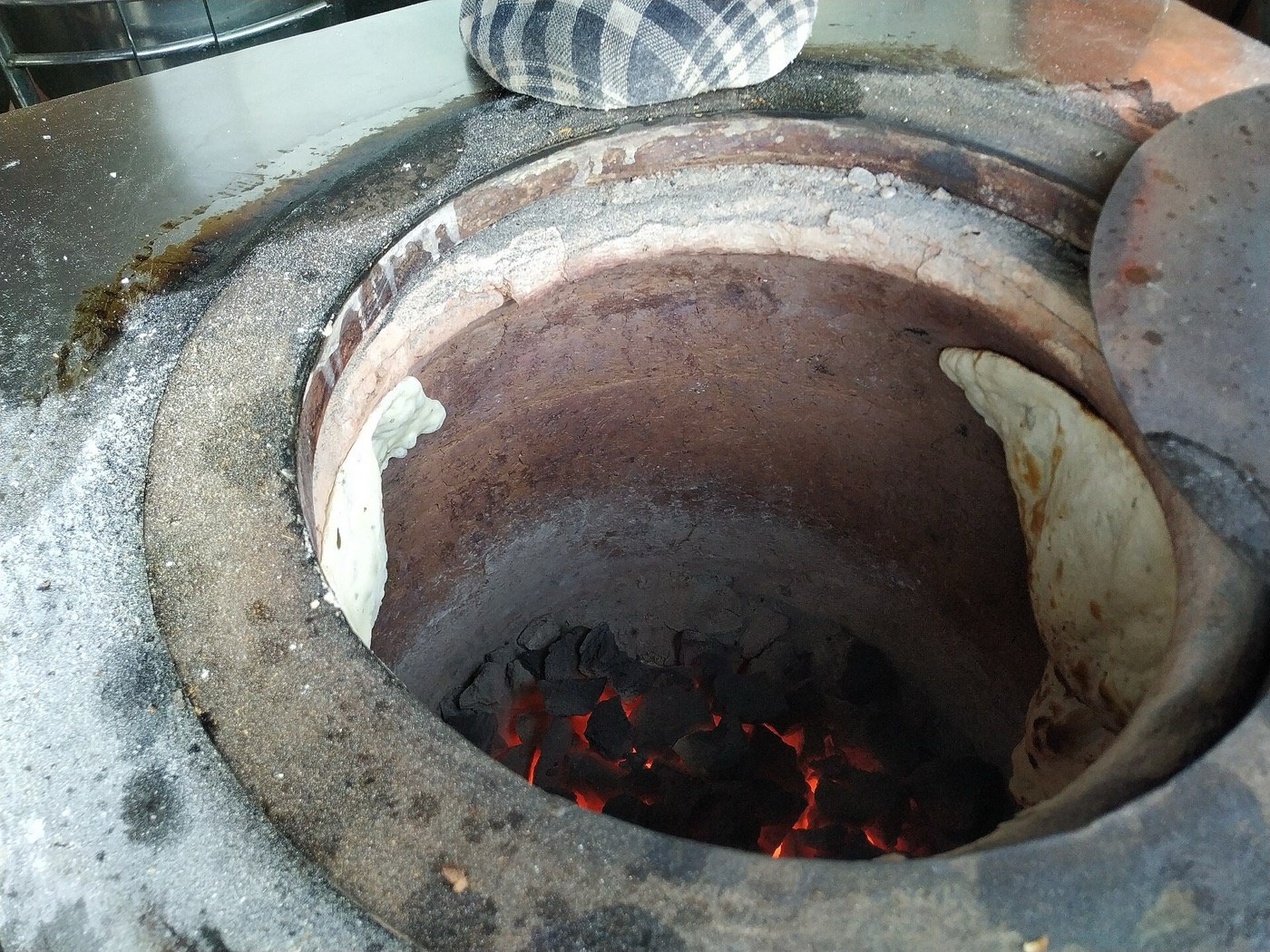 The tandoor, and the bread on its wall